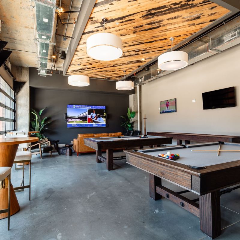 The Village at Commonwealth resident game room with billiards table and garage door